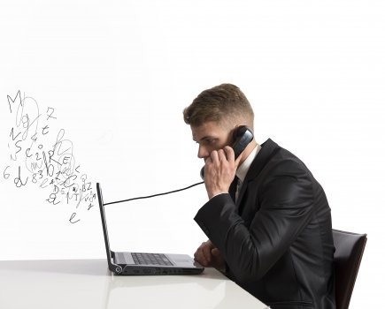 voip services ringcentral enterprise young man in black suit on laptop talking on the phone